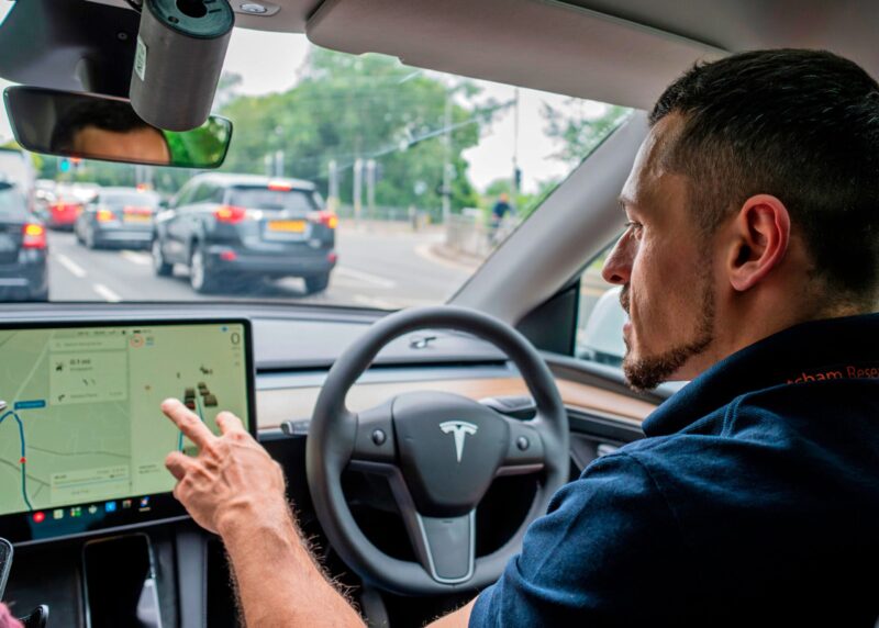Mand bag rattet i højrestyret Tesla.