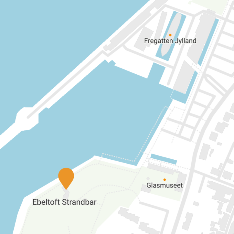 Kort, der viser Ebeltoft Strandbar, Fregatten Jylland og Glasmuseet tæt på havnefronten i Ebeltoft, Danmark. Land, vand og gader er afbildet, og stederne er markeret med orange nåle.