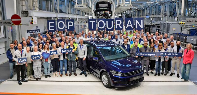 Blå VW Touran med en masse personer rundt om.